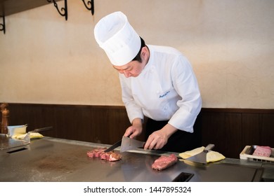 Kobe, Japan: October 11, 2018: A Japanese Chef Cooks Kobe Beef Steaks At A Steakhouse. Kobe Beef Is A Wagyu Beef Raised According To Strict Standards In Japan.