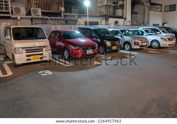 KOBE, JAPAN-NOVEMBER 10, 2018: Cars parked in\
reverse in Kobe, Japan. It is common for Japanese to park their\
cars in reverse  (back in)\
parking.