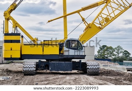 Kobelco Crawler crane isolated front view on a construction site with focus on the machine deck, counterweight and treads.