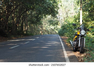 Kochi, Kerala - 1 December 2018 - A yellow colored Royal Enfield Continental GT motorcycle parked by the side of a highway. 
