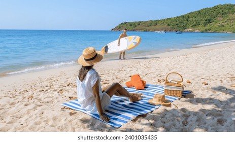 Koh Larn Island near Pattaya Thailand, the tropical beach of Koh Larn Thailand, a white beach with clear water ocean. Tropical Island. a couple of men relaxing on the beach with a sup board - Powered by Shutterstock