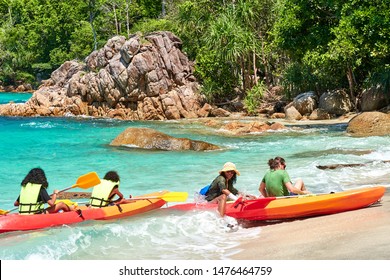 Koh Lipe,Thailand - Jul. 17 2019 - Multiracial Family In Kayak Arriving At A Wild And Tropical Paradise Beach With Waves