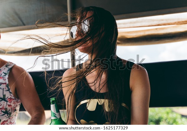 Koh Rong\
Samloem / Cambodia - 12/01/2018: Flying hair of the girl sitting in\
the back of the truck in\
Cambodia