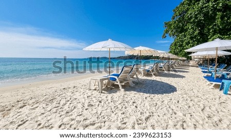 Koh Samet Island Rayong Thailand, beach chairs sunbed with umbrellas at the white tropical beach of Samed Island with a turqouse colored ocean and a blue sky