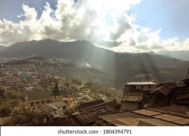 Kohima, Nagaland, India - November 2014: A Landscape Of The City Of Kohima In Northeast India With Sun Light Shafts Falling From The Cloudy Sky On The Surrounding Hills.