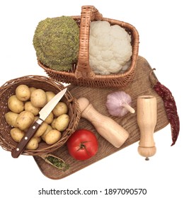 Kohlrabi With Cauliflower Cabbage And White Potato In Wicker Baskets. Tomato, Garlic, Chili Pepper,Paring Knife, Salt And Pepper Mill on Old Wooden Cutting Board Isolated On White Background, Top View - Powered by Shutterstock