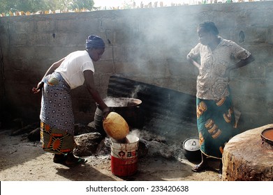 KOKEMNOURE, BURKINA FASO - FEBRUARY 23: Reserved large pot for cooking local beer in Burkina Faso , a woman takes care of the cooking, february 23, 2007 