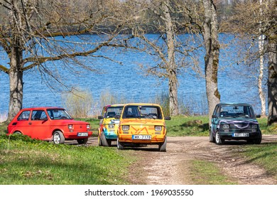 Koknese, Latvia - May 01, 2021: several colorful oldtimer PanCars rental cars Fiat 126 parked on the side of a country road