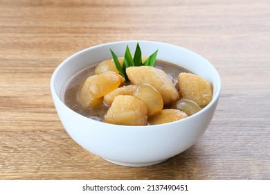 Kolak, Kolak Pisang is Indonesian traditional dessert, very popular during Ramadhan, made from banana with coconut milk, sugar and pandanus leaves. Served in white bowl on wooden table. - Shutterstock ID 2137490451