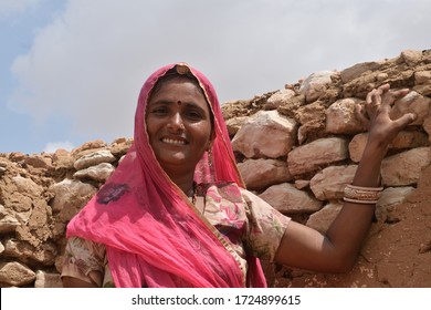 Kolayat, Bikaner, Rajasthan / India, September 03,2017: Horizontal view Beautiful Rajasthani woman laughing in the mud hut of ruins of a village farm in Kolayat