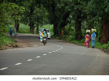 Kolhapur,Maharashtra,India-September 13th 2019;Stock Photo Of Beautiful Indian Village Road, Women Walking And Carrying Bag On Her Head, Motorbike And Car Moving Forward On Asphalt Road .