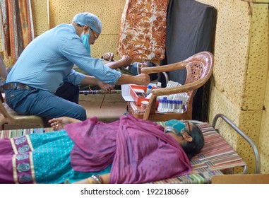 Kolkata, 02-21-2021: A Lab Technician Wearing Protection Head Cap And Face Mask , Sitting Beside Blood Donors During Blood Transfusion Process. Shot Inside A Blood Donation Camp.