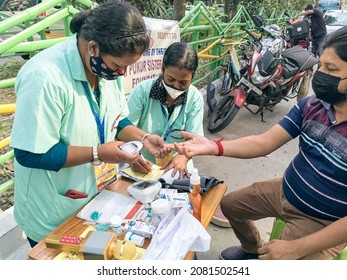 Kolkata, 11-01-2021: Health Technicians Checking Blood Sugar Level Of A Person, Using A Digital Glucometer At A Roadside Free Health Checkup Camp Organised By An NGO, At Sector V, Saltlake.