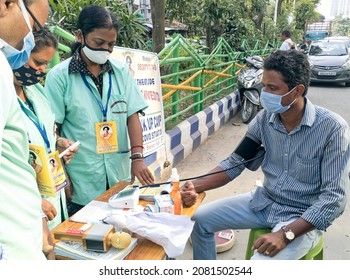 Kolkata, 11-01-2021: Health Technicians Checking Blood Pressure Level Of A Person, Using A Digital BP Machine At A Roadside Free Health Checkup Camp Organised By An NGO, At Sector V, Saltlake.