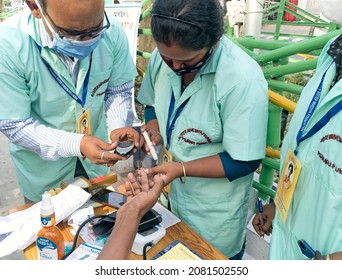 Kolkata, 11-01-2021: Health Technicians Checking Blood Sugar Level Of A Person, Using A Digital Glucometer At A Roadside Free Health Checkup Camp Organised By An NGO, At Sector V, Saltlake.