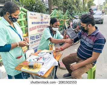 Kolkata, 11-01-2021: Health Technicians Checking Blood Sugar Level Of A Person, Using A Digital Glucometer At A Roadside Free Health Checkup Camp Organised By An NGO, At Sector V, Saltlake.