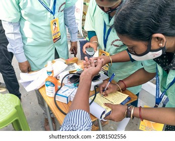 Kolkata, 11-01-2021: Health Technicians Checking Blood Sugar Level Of A Person, Using A Digital Glucometer At A Roadside Free Health Checkup Camp Organised By An NGO, At Sector V, Saltlake.