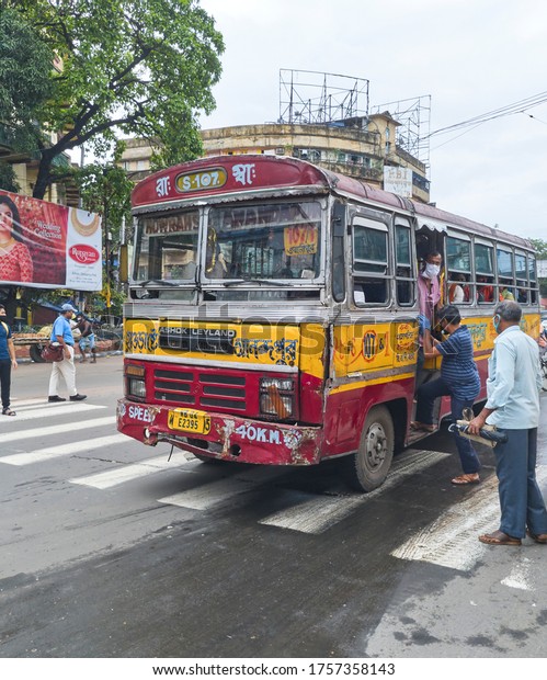 Kolkata,\
6/13/2020: India Unlock 2.0. A minibus conductor, wearing face mask\
seen standing at bus door. Few people are boarding the bus. Traffic\
movement is gradually becoming normal in\
city.