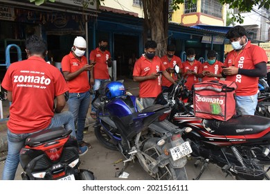 Kolkata, India, 17-07-2021 - Delivery Workers Of Zomato, An Indian Food-delivery Start-up, Wearing Face Masks Check Their Phones As They Wait To Collect Orders Outside A Restaurant In Kolkata.