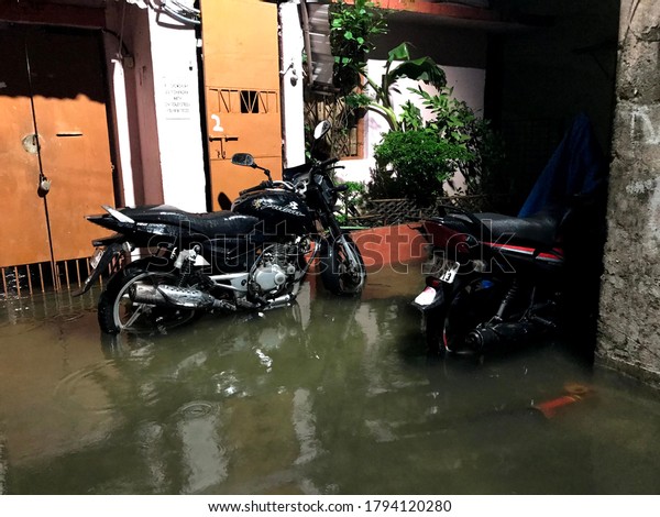 Kolkata India, 2020. A bike submerged\
in water clogged street after heavy rainfall in\
Kolkata