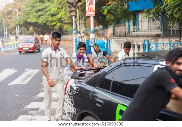 KOLKATA, INDIA - 22 Oct 2016: Young men push a\
broken down car on the morning of October 22, 2016 in Kolkata\
(Calcutta), India