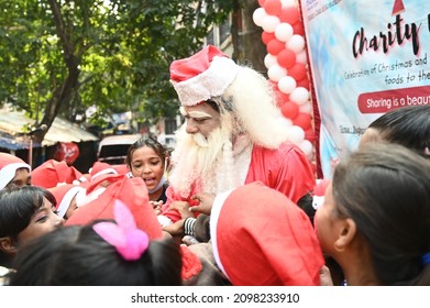 Kolkata, India, 25th December 2021: Santa Claus Giving Presents And Gifts During Christmas To The School Kids, A Charity Event Organised By NGO For Poor Kids In Kolkata, West Bengal.