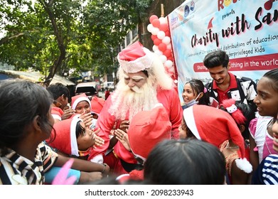 Kolkata, India, 25th December 2021: Santa Claus Giving Presents And Gifts During Christmas To The School Kids, A Charity Event Organised By NGO For Poor Kids In Kolkata, West Bengal.