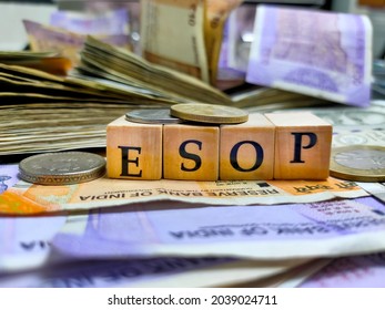 Kolkata, India, Dated 08.09.2021. ESOP or employee stock ownership plan by letters on wooden beads or block with Indian rupee notes and coins.