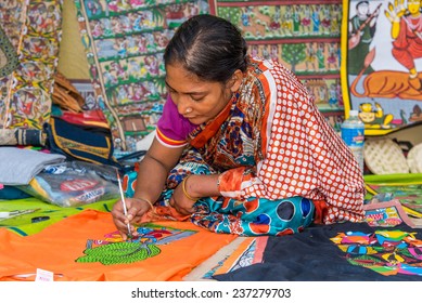 KOLKATA; INDIA - DECEMBER 11: An Indian craftswoman paints on colorful handicraft items for sale during the annual State Handicrafts Expo 2014 on December 11; 2014 in Kolkata; West Bengal; India.