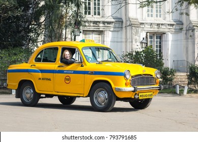 KOLKATA, INDIA - JANUARY 10, 2018: A Tourist Sits In An Indian Yellow Taxi Hindustan Motors Ambassador Model