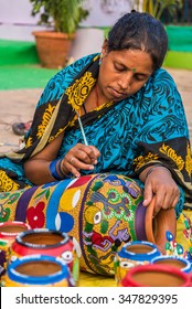 KOLKATA, INDIA - NOVEMBER 24: An Indian craftswoman paints on colorful handicraft items for sale during the annual State Handicrafts Expo 2015 on November 24, 2015 in Kolkata, West Bengal, India.