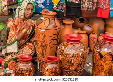 KOLKATA, INDIA - NOVEMBER 26: A rural craftswoman paints on colorful handicraft items for sale during the annual State Handicrafts Expo 2016 on November 26, 2016 in Kolkata, West Bengal, India.