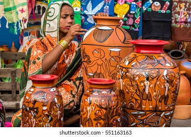 KOLKATA, INDIA - NOVEMBER 26: A rural craftswoman paints on colorful handicraft items for sale during the annual State Handicrafts Expo 2016 on November 26, 2016 in Kolkata, West Bengal, India.