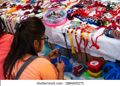 Kolkata, West Bengal, India - 31st December 2018 : Woman selling various shapes and shades of necklaces, bags and other fashion objetcs, handicrafts on display during the Handicraft Fair in Kolkata.