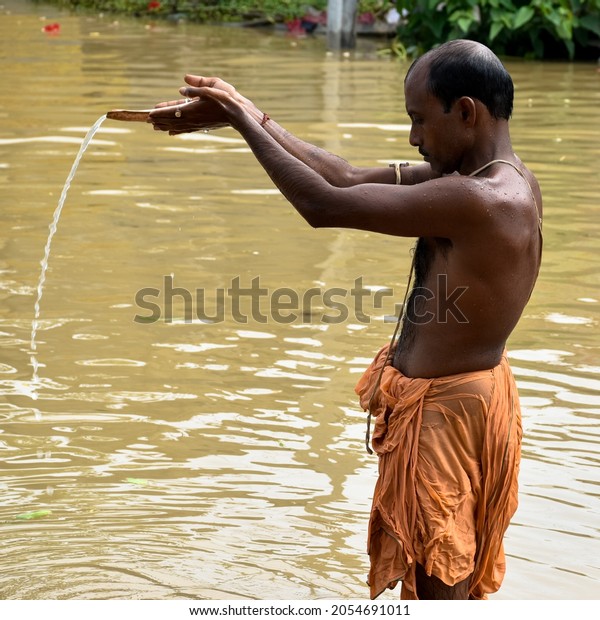 Kolkata, West\
Bengal, India - 6th October 2021 : TARPAN - A Hindu ritual, the\
sacrament of offering drinking water to the manes. This is well\
practised on Mahalaya day by hindu\
devotee.