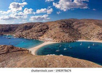 Kolona two sided sandy beach, aerial drone view. Greece, Kythnos island, Cyclades. Sailboats anchored offshore, calm sea, blue sky background. Summer vacation and sailing in Aegean sea