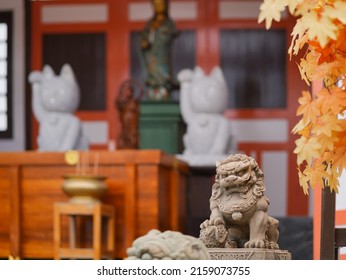 Koma inu. Koma inu means Lion guardian at the Japanese shrine, soft focus. Symbol of protector at shinto temple. On the blurred background is Maneki Neko (fortunate cat) and goddess of Merci, Guan Yin - Shutterstock ID 2159073755