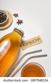 Kombucha-Flasche mit "Kombucha" darauf und ein Glas Wein