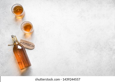 Kombucha fermented drink in glass and bottle on white background, copy space. Heathy probiotic drink - kombucha.