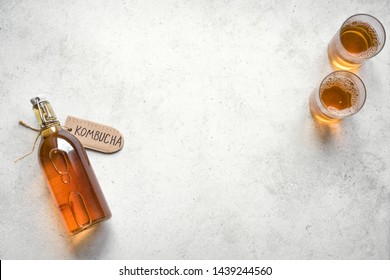 Kombucha fermented drink in glass and bottle on white background, copy space. Heathy probiotic drink - kombucha.