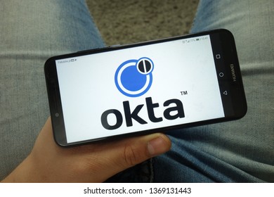 KONSKIE, POLAND - April 13, 2019: Man holding smartphone with Okta logo