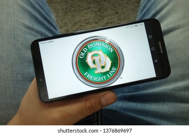 KONSKIE, POLAND - April 13, 2019: Man Holding Smartphone With Old Dominion 
Freight Line Company Logo