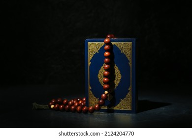 Koran And Muslim Prayer Beads On Dark Background