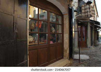 Korce, Albania - February 11, 2022: Thrift Store At Old Bazaar Of Korce. Items For Sale. Shop Window Display. Panel Painting Artwork.