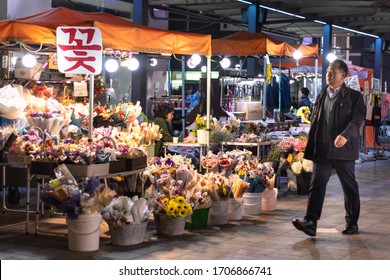 Korea; Oct 2019: Man Passing By A Flowers Stall At Night. Street Market. Man Coming Back Home From Work Or A Dinner With Colleagues  Friends. Autumn Or Winter Time. Seoul, South Korea, Asia