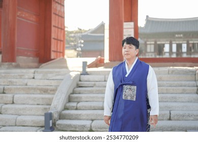 A Korean couple, a man in his 30s and a woman in her 20s, walks harmoniously through a historical building in Seoul, South Korea, wearing Hanbok. - Powered by Shutterstock