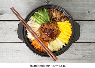 Korean cuisine, beef  Bibimbap in  a clay pot on wooden table