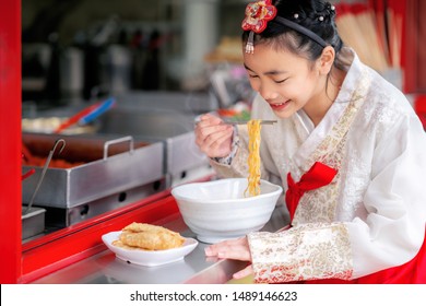 Korean girl eat a noodle with Korean traditional dress in old and vintage restaurant, seoul city, south korea