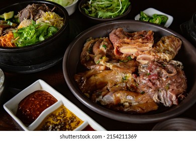 Korean Grilled BBQ combo with marinated beef pork meat set on the traditional grill table, with bibimbap, dipping sauce and pickle dishes - Shutterstock ID 2154211369