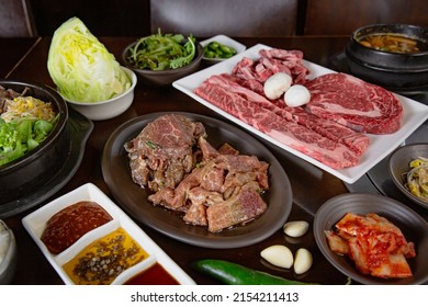 Korean Grilled BBQ combo with wagyu and marinated beef set on the traditional grill table, with lettuce, dipping sauce, rice and pickle dishes - Shutterstock ID 2154211413